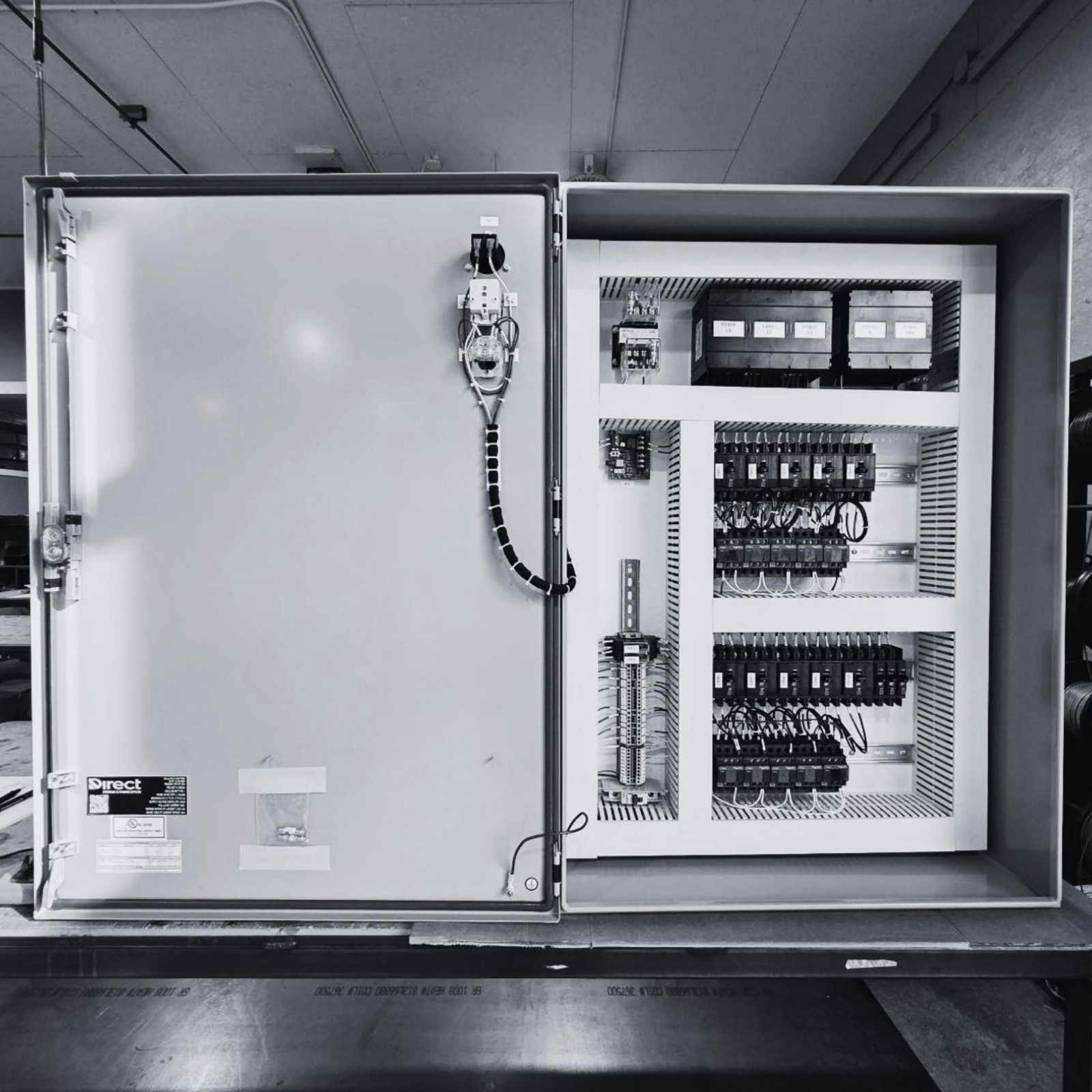 Open industrial control panel showing electrical components, wiring, and enclosure assembly during fabrication