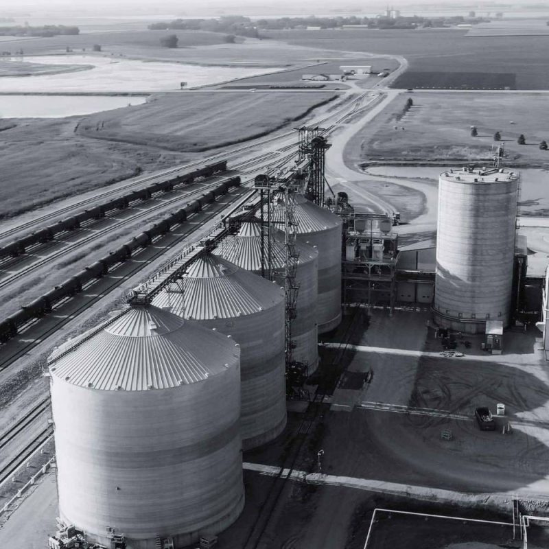 Aerial view of an ethanol production facility with storage tanks and rail access