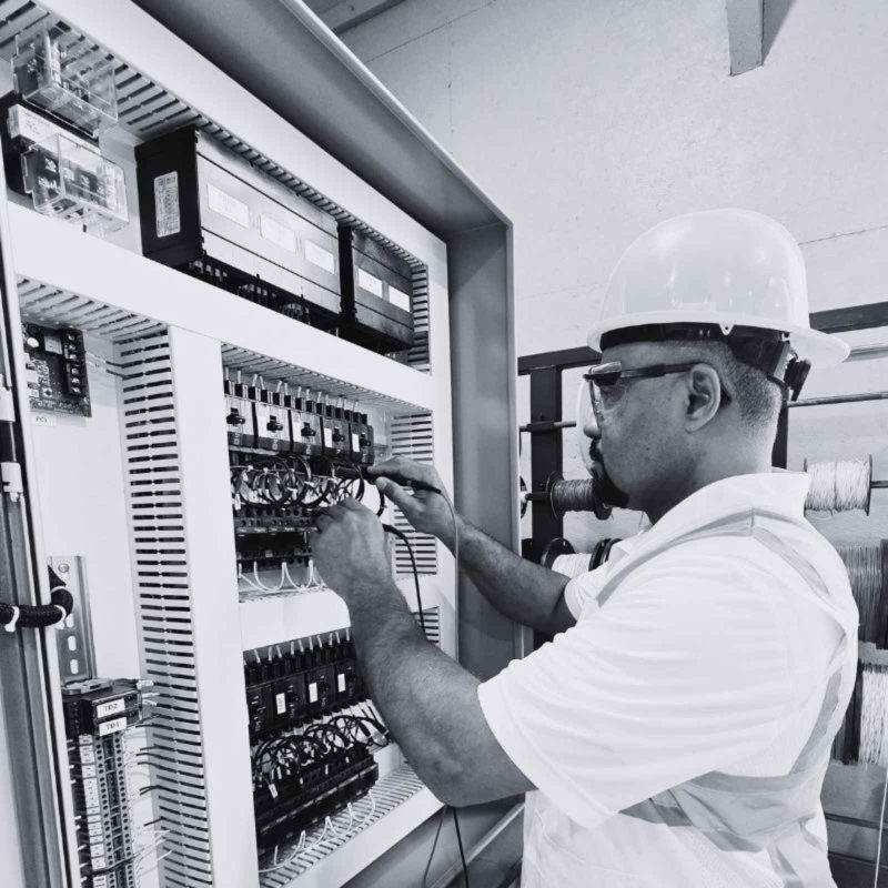 Technician wiring and assembling an industrial control panel in the fabrication shop