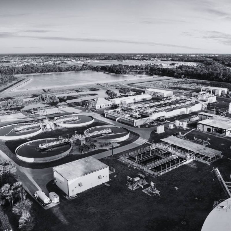Aerial view of a water and wastewater treatment facility with treatment basins and process equipment