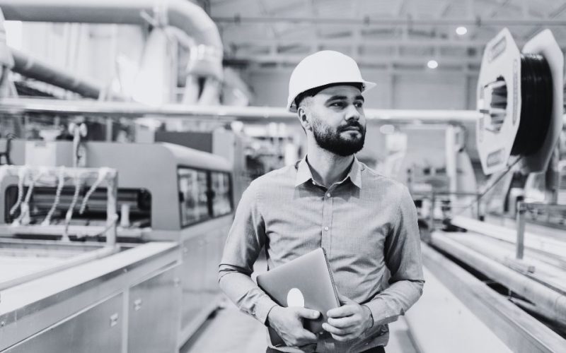 Engineer reviewing panel fabrication process with clipboard showing how outsourcing improves supply chain resilience